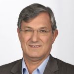Bernd Riexinger Porträt von Bernd Riexinger, Parteivorsitzender DIE LINKE, mit grauen Haaren und Brille, in einem Anzug vor hellem Hinter...