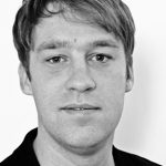 Thomas Trappe Porträt eines Mannes mit kurzen, blonden Haaren und einem neutralen Gesichtsausdruck vor einem hellen Hintergrund.