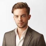 Daniel Wixforth Porträt eines jungen Mannes in Anzug mit offenem Hemdkragen, vor hellem Hintergrund.