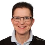 Petra Sitte Porträt einer lächelnden Frau mit kurzen, dunklen Haaren und Brille, trägt einen schwarzen Pullover mit Kragen.