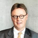 Michael Grosse-Brömer Porträt eines Mannes mit Brille, grauen Haaren und Anzug, vor einer neutralen Wand.