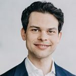 Christoph Ploß (CDU) Porträt von Christoph Ploß, CDU, mit lächelndem Gesicht, in Anzug vor neutralem Hintergrund.