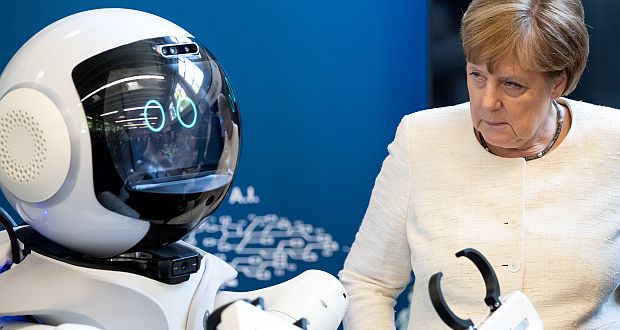 Bundes­kanzlerin Angela ­Merkel schaut sich bei ­einem Rundgang durch die Munich School of Robotics and Machine ­Intelligence der ­Technischen ­Universität München ­einen "Pflege­roboter" an. (c) picture alliance/dpa/Sven Hoppe