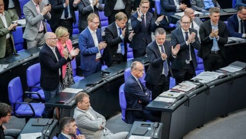 Die Unionsfraktion applaudiert ihrem Fraktions- und Parteichef Friedrich Merz (sitzend). Dieser will mit angriffslustigen Reden politische Debatten zurück ins Parlament tragen. (c) picture alliance/dpa/Kay Nietfeld
