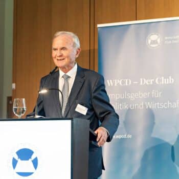 Prof. Dr. Otmar Issing spricht am Rednerpult bei der Preisverleihung des WPCD, im Hintergrund ein Banner des Clubs.