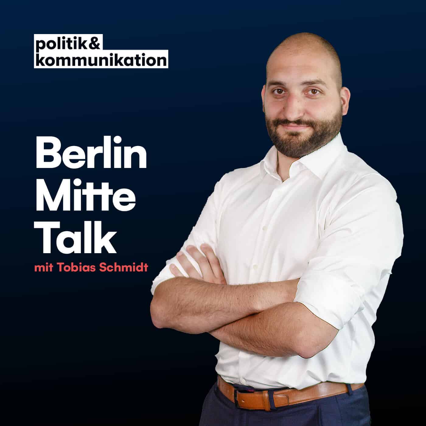 Mann in weißem Hemd vor dunklem Hintergrund, Titel „Berlin Mitte Talk“ und Logo von politik&kommunikation.