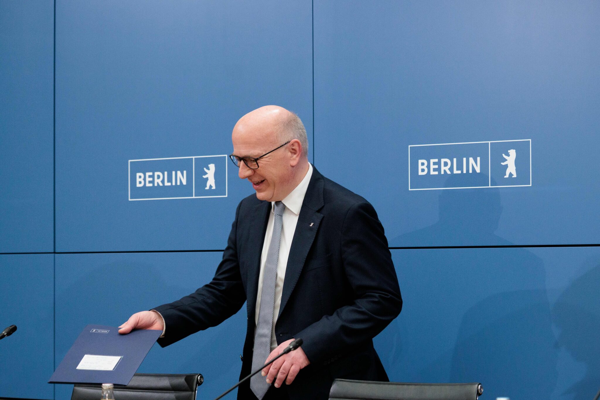 Kai Wegner, Regierender Bürgermeister von Berlin, hält ein Dokument während einer Pressekonferenz im Roten Rathaus.