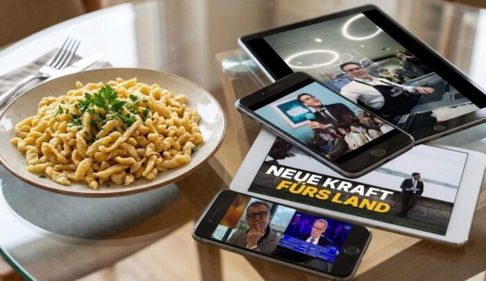 Teller mit Pasta und Kräutern auf einem Tisch, umgeben von mehreren Geräten, die Social-Media-Inhalte zeigen.