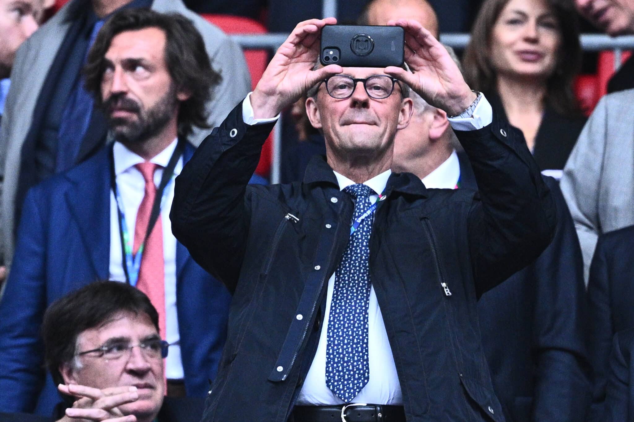 Friedrich Merz fotografiert mit einem Smartphone im Wembley Stadion während des Spiels Borussia Dortmund gegen Real Madrid.