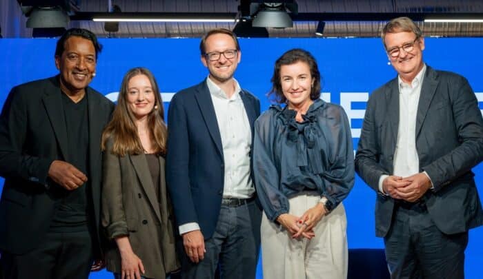 Fünf Personen stehen lächelnd vor einem blauen Hintergrund bei der Auftaktveranstaltung „Digital Heroes“ bei SAP.
