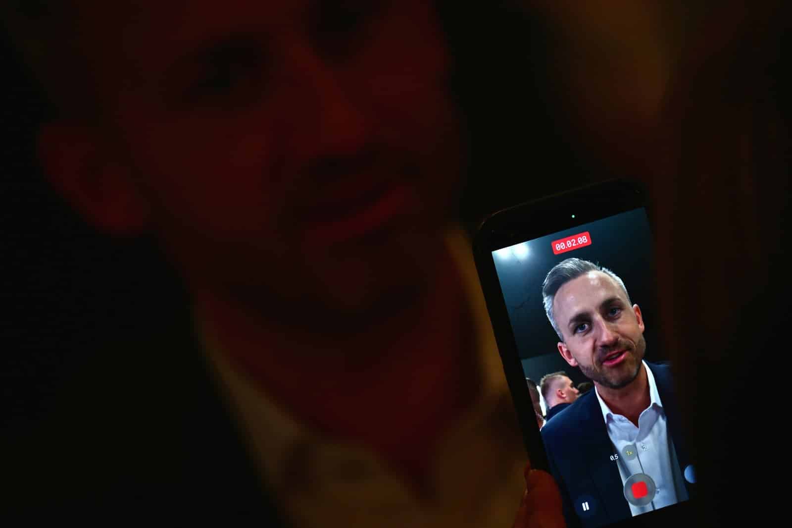 Ulrich Siegmund (AfD) auf dem Bildschirm eines Smartphones bei der AfD-Wahlparty in Magdeburg