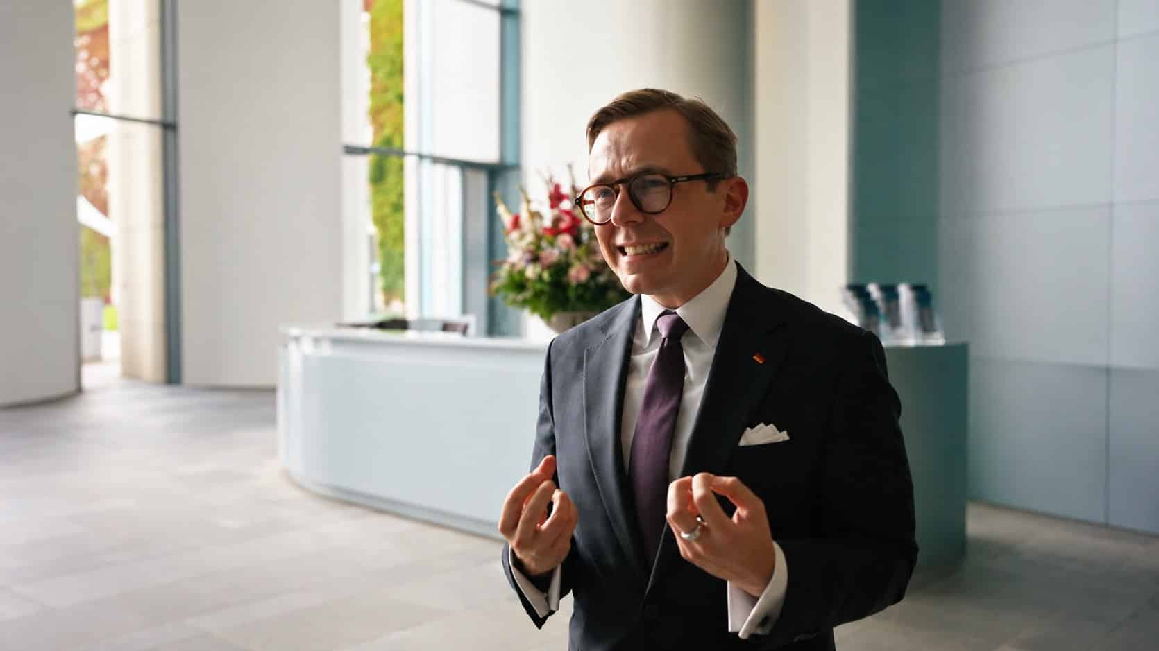 Philipp Amthor im Anzug mit Einstecktuch gestikuliert in der Eingangshalle des Kanzleramts.